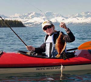 Allan prepares to release a baby halibut she caught from her kayak in Prince William Sound. Photo courtesy of Sarah Allan.