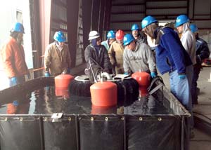 Fishing vessel crews learn to set up and run a small brush skimmer during this year's Spring training in Cordova. Photo by Serena Lopez.