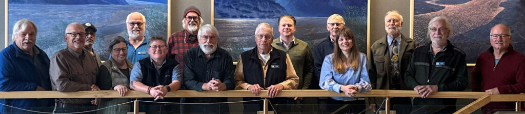 Fifteen of the Council's 20 Board of Directors stand in front of a series of public art paintings in the Cordova Center where the September 2025 meeting was held.
