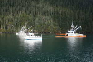 Photo of fishing vessels pulling oil spill boom in formation. If the vessels move too fast, too slow, or get out of proper formation, their efforts to collect oil are not as effective.