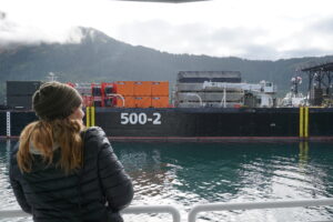 Photo of an onlooker viewing the oil spill support barge, the "500-2". This barges carries response equipment such as skimmers and boom.