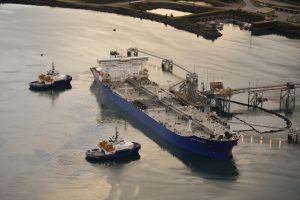 Photo of two escort tugs assisting a tanker at the Valdez Marine Terminal’s oil loading docks.