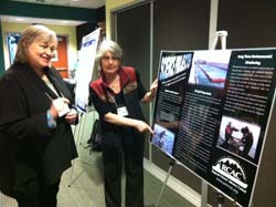 At a 2012 conference, Linda shows a poster about the council’s science projects to Sue Saupe, Director of Science and Research at Cook Inlet Regional Citizens’ Advisory Council.