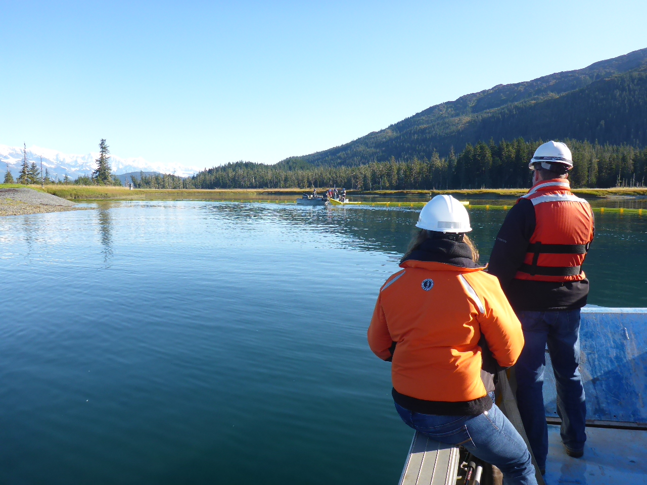 Photo of Representatives from the Alaska Department of Environmental Conservation and SERVS observing an oil spill exercise in Prince William Sound.