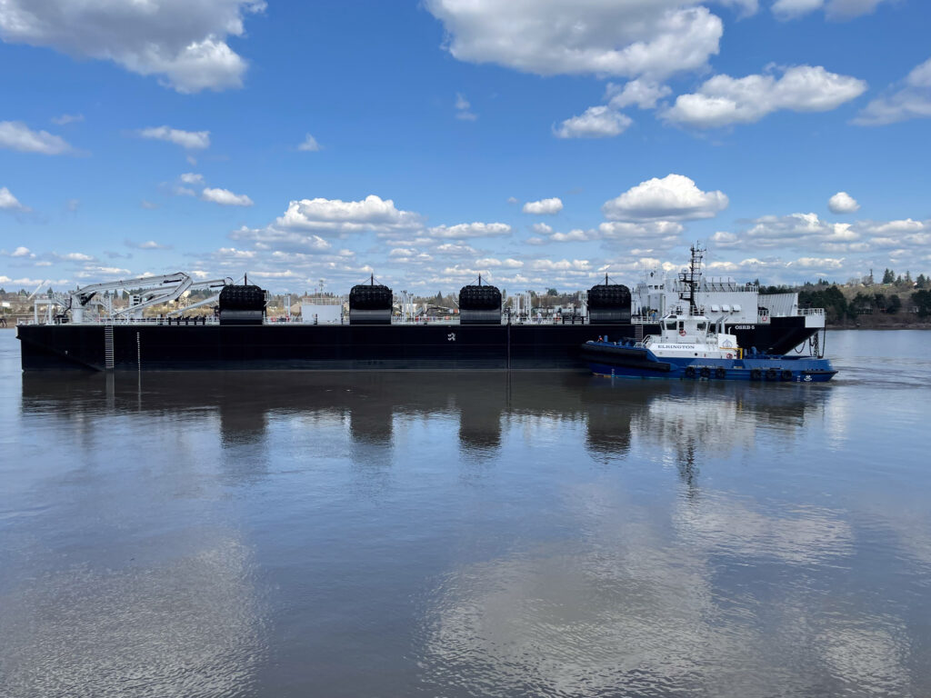 This photo shows a new oil spill response barge with an escort tug alongside the barge. 