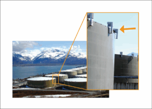 The image shows two photos. One is a distance shot of the storage tanks, which demonstrates how vast the tanks are. The second photo is a closeup of the vents, which are metal and stick up off of the top edge of the tanks.