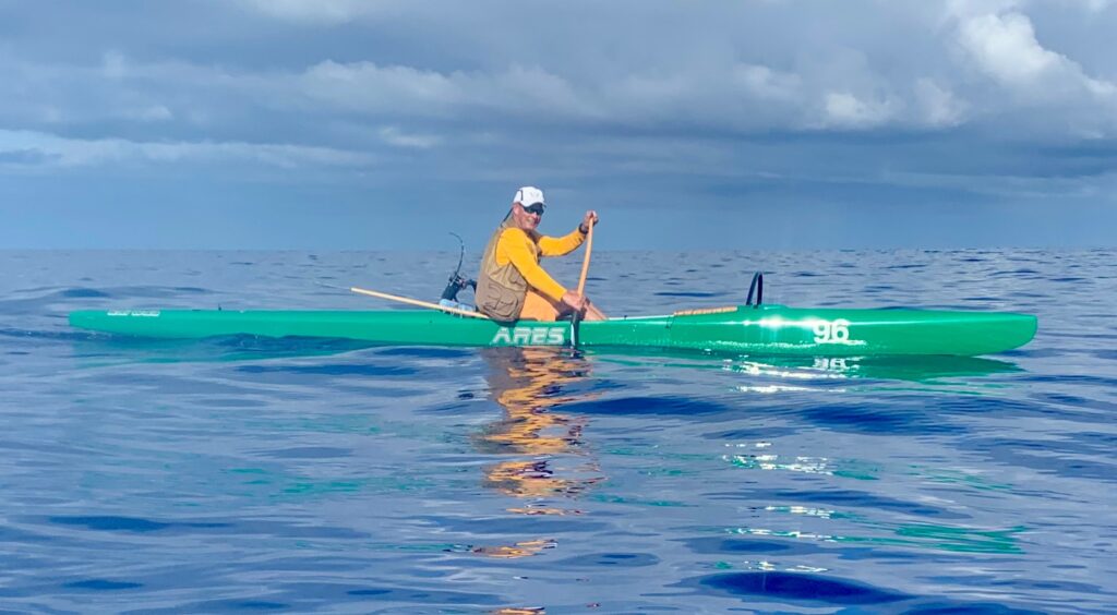 Photo of Tim Robertson paddling a kayak on the ocean.